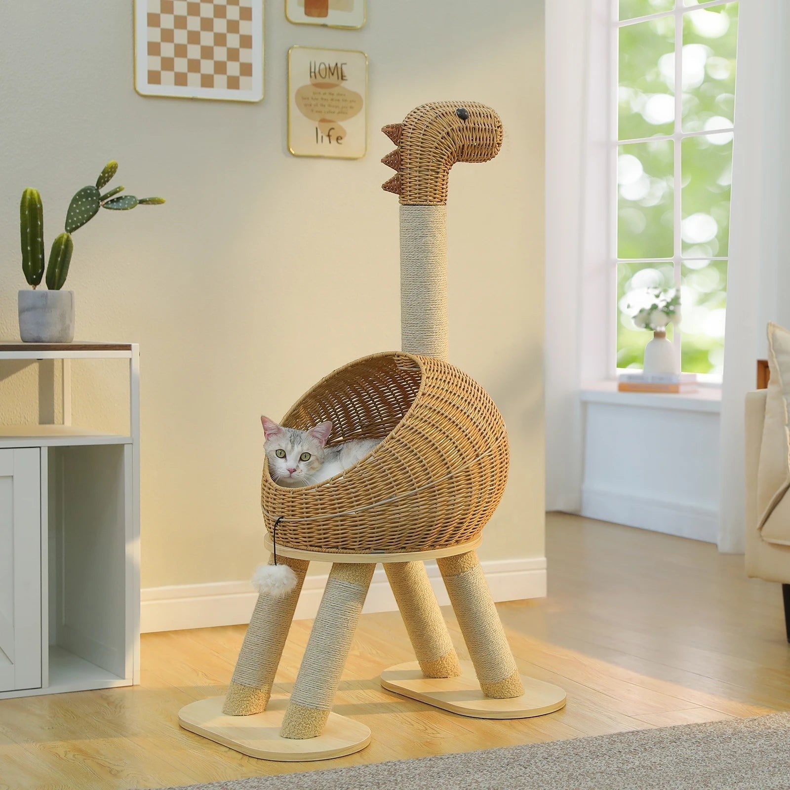 Tailwag Factory dinosaur-shaped cat tree with a rattan bed and sisal-wrapped legs, featuring a cat resting inside.